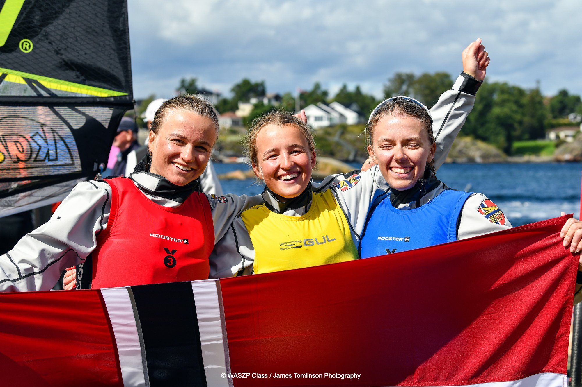 PÅ PALLEN: Hedvig Doksrød fra Sandefjord Seilforening er verdensmester i Waszp 8.2 for kvinner. Med seg på pallen fikk hun Marie Butler Wang fra Tønsberg Seilforening på sølvplass og storesøster Nora Doksrød fra Sandefjord Seilforening på bronse. Foto: James Tomlinson/Waszp Games 2024