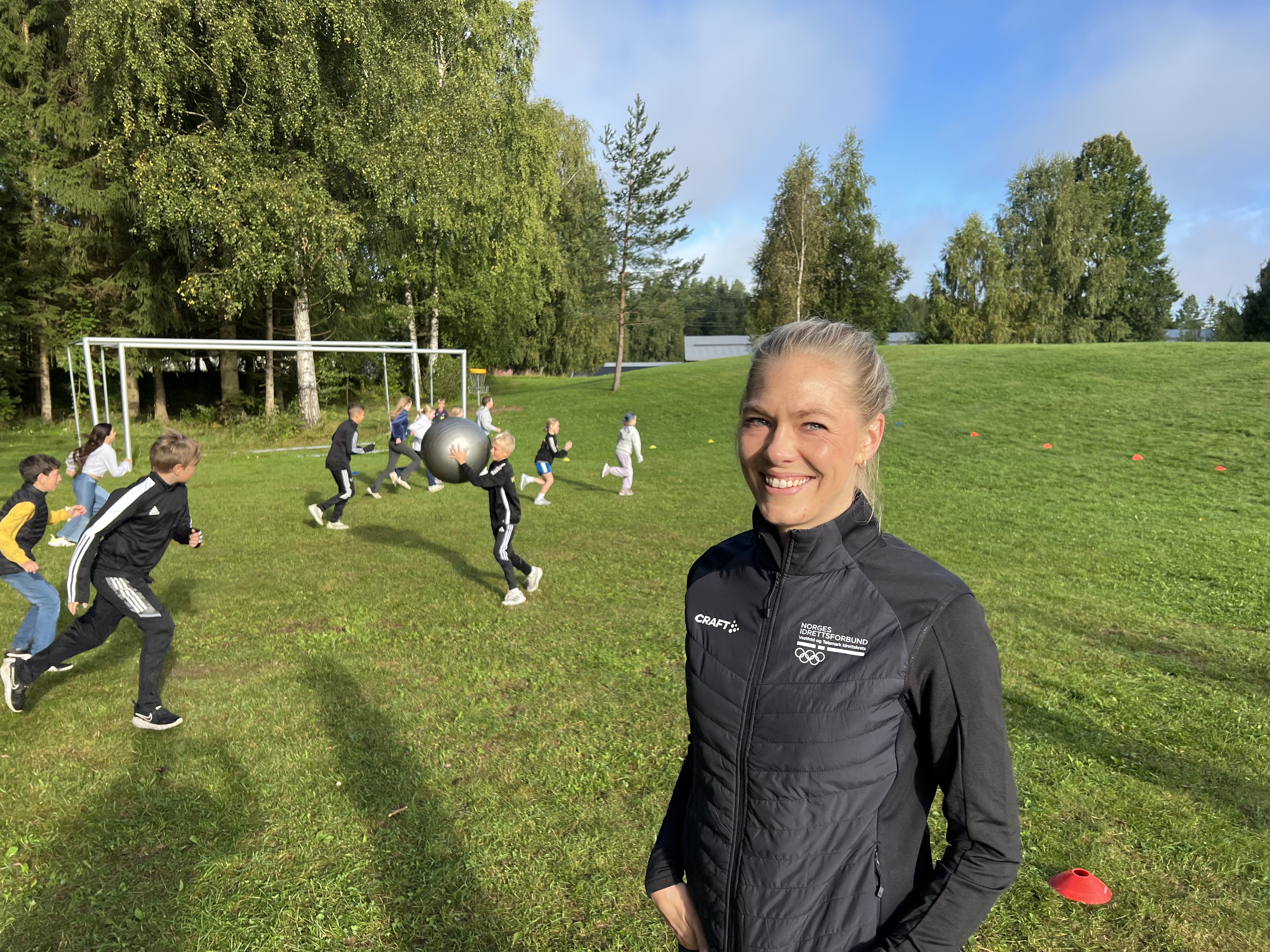 Prosjektleder, Karoline Riis fra Vestfold og Telemark idrettskrets elsker å se aktivitetsgleden de unge viser under Aktiv365-kurset. I bakgrunnen er ett av de mange kullene i Aktiv365 godt i gang med aktivitetslederutdanningen.