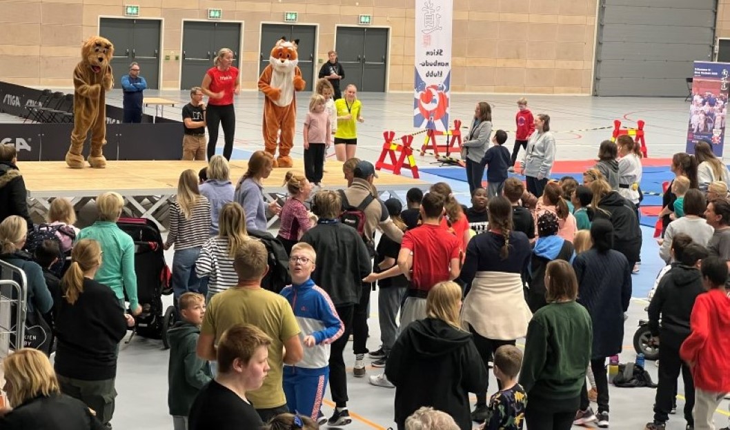 Oppvarming sammen med Friskis&Svettis Grenland skapte god stemning og var en gøy start for alle deltagere. Maskotene deltok aktivt i dansen. Foto: Vestfold og Telemark idrettskrets